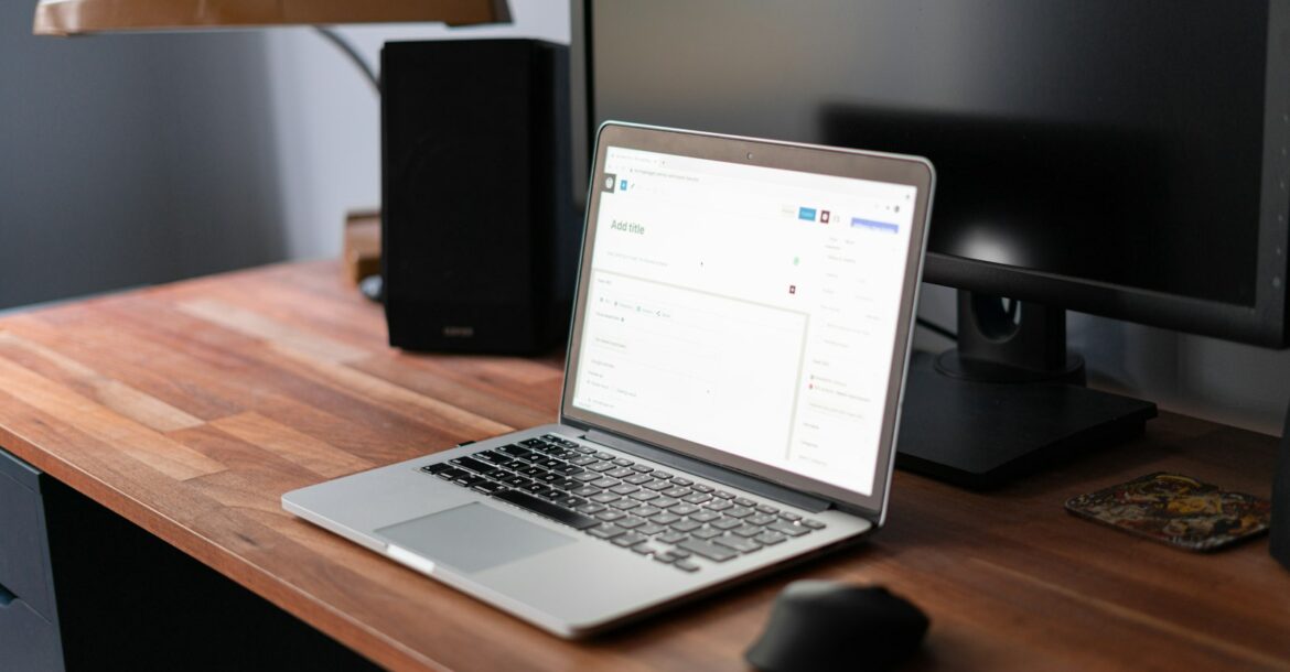 Notebook sobre un escritorio de madera con el editor de WordPress abierto en pantalla